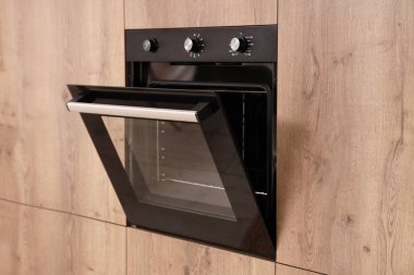 Modern mutfakta ahşap mobilya ve fırın.