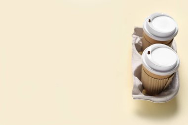 Bej arkaplanda bulunan paket kağıdı bardakları