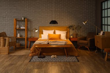 Yatak odasının içinde koltuklar, parlayan lambalar ve geceleri ahşap banklar.