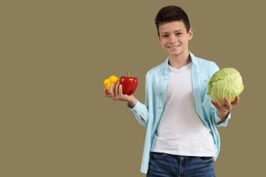 Yeşil arka planda dolmalık biberli ve lahanalı şirin küçük çocuk.