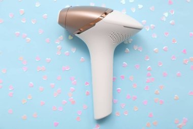 Renk arkaplanındaki modern fotoepilatör ve kalp şeklinde pullar