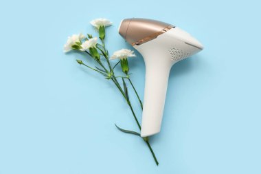 Modern fotoepilatör ve güzel karanfil çiçekleri.