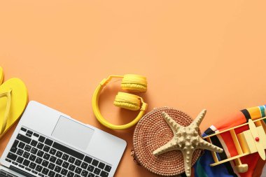 Dizüstü bilgisayar, kulaklık, plaj aksesuarları ve renk arkaplanlı oyuncak uçak kompozisyonu