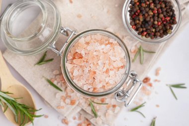 Kavanozlu Himalaya pembe tuzu ve beyaz arka planda cam biber kasesi