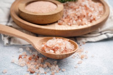 Tahta kaşık ve tabak beyaz arka planda Himalaya pembe tuzu