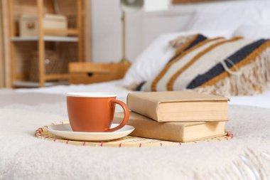 Bir fincan çay ve kitap yatak odasında, yakın plan.