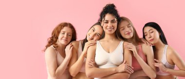 Pembe arka planda bir grup mutlu genç kadın. Kız gücü