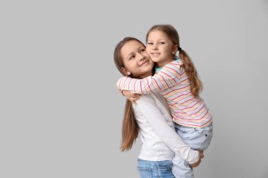 Sevimli küçük kız kardeşler sarılıyor arka planda