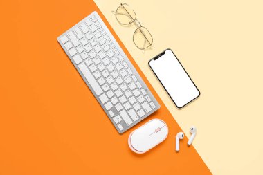 Renkli arka planda modern cihazlar ve gözlüklerle kompozisyon