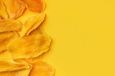 Turuncu arka planda kurutulmuş mango dilimleri