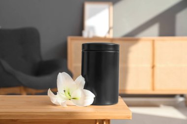 Morg vazosu ve beyaz zambak çiçeği odasındaki ahşap masada.