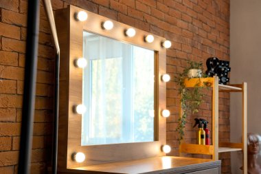 Modern soyunma odasında aynalı masa tuğla duvarın yanında.