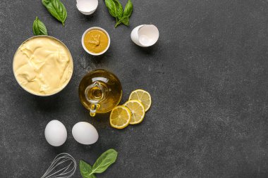 Bir kase taze mayonez ve siyah arka planda malzemeler.