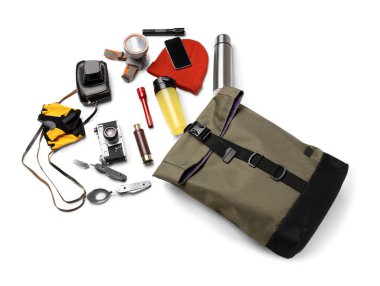 Beyaz arka planda sırt çantası ve açık hava teçhizatı ile yürüyüş için gerekli malzemeler.