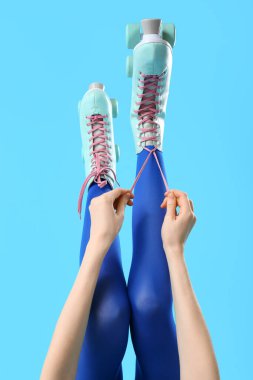 Mavi arka planda patenli kadın bacakları