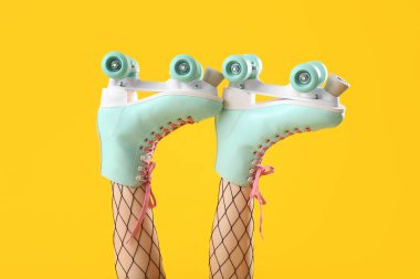 Sarı arka planda patenli kadın bacakları