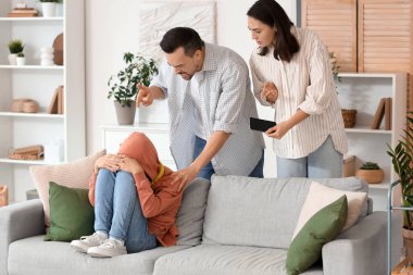 Genç çocuk kanepede oturuyor ve ailesi evde tartışıyor. Aile sorunu kavramı