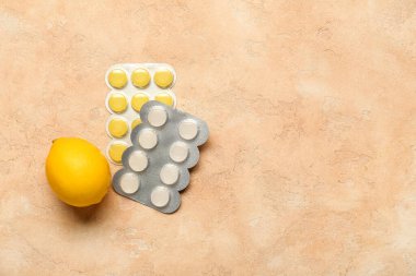 Ağrıyan boğaz için haplar ve bej renginde limon.