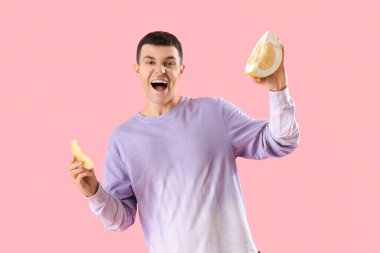 Pembe arka planda kesilmiş çiçekli genç adam.