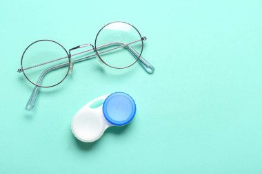 Turkuaz arka planda kontak lensler için gözlük ve kap