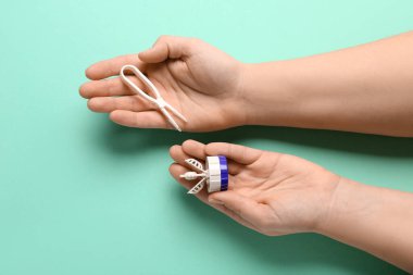 Kontak lensler ve turkuaz arka planda cımbız için temizlik çantası olan kadın elleri