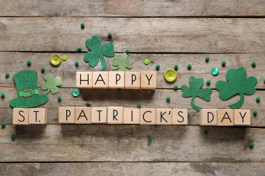 Kağıt yoncalı küpler ve tahta arka planda düğmeler. Aziz Patrick Günü kutlaması