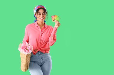 Yeşil arka planda kredi kartları ve çiçek demeti olan şık bir Afro-Amerikalı kadın. Uluslararası Kadınlar Günü kutlamaları