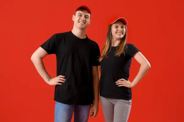 Young couple in black t-shirts on red background