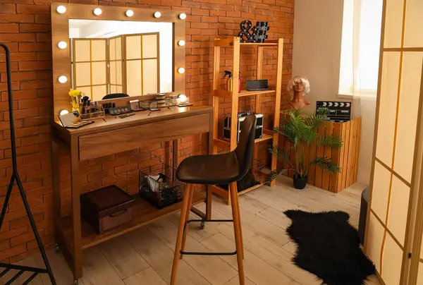 Stylish mirror and table with makeup cosmetics in dressing room