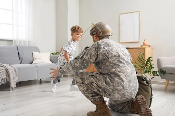 Little boy running to his military father at home
