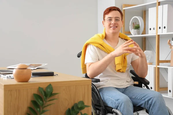 Portrait of young man in wheelchair at office