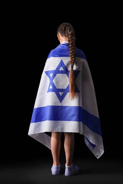 Little Jewish girl with flag of Israel on black background, back view. International Holocaust Remembrance Day