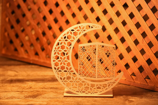 Decorative crescent for Ramadan on wooden table, closeup
