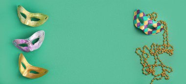 Yeşil arkaplandaki karnaval maskeleri ve boncukları metin için alan