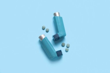 Astım spreyleri ve mavi arka planda haplar.