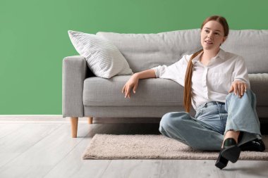 Uzun bir çalışma gününden sonra genç bayan evde dinleniyor.