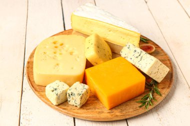 Beyaz ahşap arka planda lezzetli peynirli tabak.