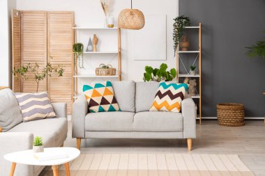 Oturma odasının içinde kanepeler ve bitkiler var.