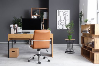 Çalışma yeri ve raf üniteleri olan modern ofisin içi