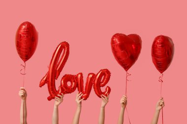 Aşk ve kalp şeklinde pembe arka planda balonları olan kadınlar. Sevgililer Günü kutlaması