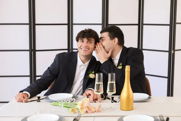 Happy gay couple at table on their wedding day