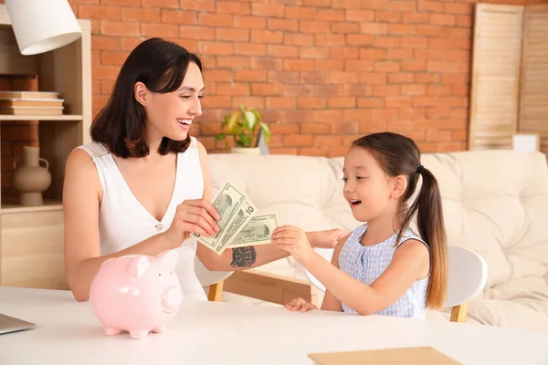 Little girl and her mother with money at home