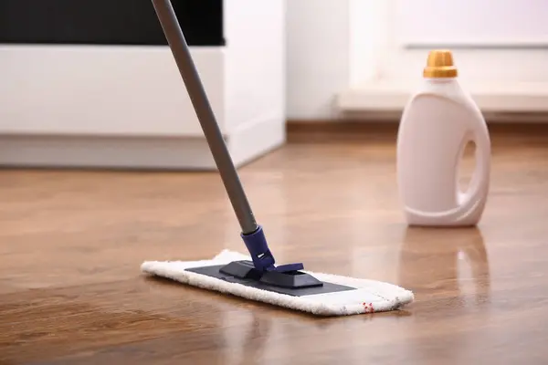 Cleaning of wooden laminate floor with mop and detergent, closeup