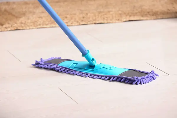 Cleaning of wooden laminate floor with mop, closeup