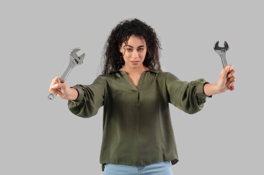 Gri arka planda ayarlanabilir anahtarı olan güzel bir Afro-Amerikalı kadın. Kadın tarihi ayı