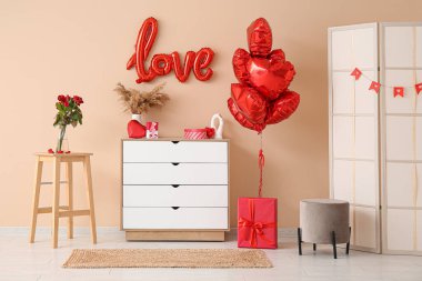 Bej duvarın yanında Sevgililer Günü kutlamaları için çekmeceleri ve süslemeleri olan oturma odasının içinde.