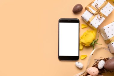 Renkli arka planda modern cep telefonu, hediye ve Paskalya dekoruna sahip kompozisyon