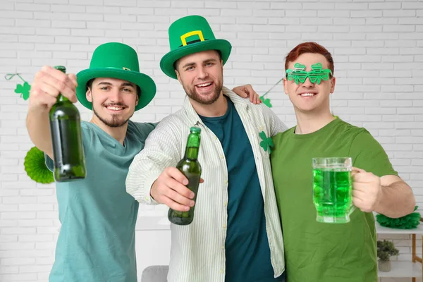 Happy young men with beer at home. St. Patrick's Day celebration