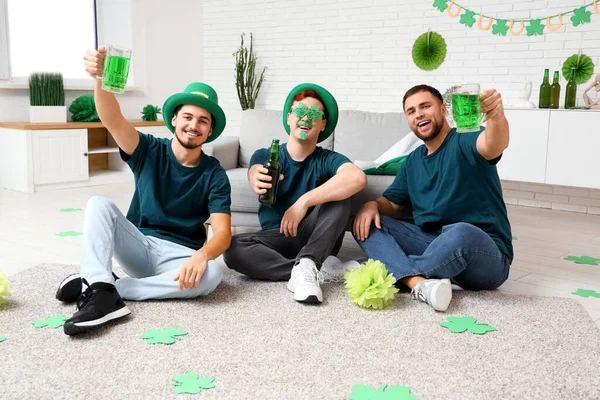 Young men with beer hugging at home. St. Patrick\'s Day celebration