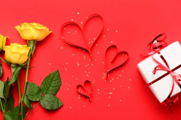赤い背景でバレンタインデーのお祝いのためのバラの花 紙のハート ギフトボックスとのコンポジション — ストック写真
